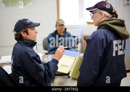 Alakanuk, Alaska, 16 luglio 2013 FEMA Individual Assistance Specialist Toby Rice and Tribal Liason Wendy Stevens talk registration options at a improvvised disaster Assistance registration session in the Town Hall offices. La FEMA sta rispondendo e ha un team che lavora con i sopravvissuti alle catastrofi, lo Stato dell'Alaska e le aree regionali di partecipazione educativa (REAA) designate. Adam DuBrowa/FEMA. Fotografie relative a disastri e programmi, attività e funzionari di gestione delle emergenze Foto Stock