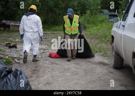 Galena, Alaska, 24 luglio 2013 due membri AmeriCorps rimuovono i detriti a mano da una casa danneggiata da alluvioni a Galena. Anche quando sono disponibili strumenti elettrici, gran parte del lavoro di disaster recovery viene eseguito manualmente. Fotografie relative a disastri e programmi, attività e funzionari di gestione delle emergenze Foto Stock