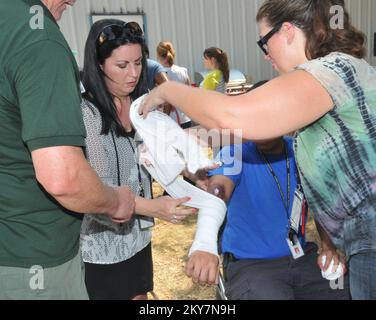 Texas, 12 settembre 2013 i dipendenti della Regione VI della FEMA Denise Bordelon (a sinistra) e Diane Dooley (a destra) si esercitano a dividere un braccio durante un evento del mese della preparazione nazionale tenutosi nella Regione VI della FEMA. .. Fotografie relative a disastri e programmi, attività e funzionari di gestione delle emergenze Foto Stock