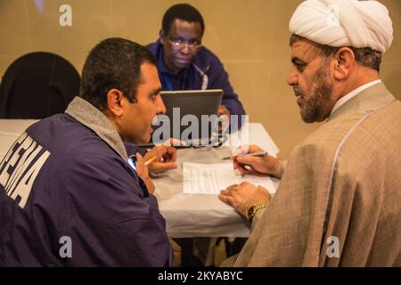 Dearborn, MI, 17 ottobre 2014 - Mohsin Mahmood (a sinistra), FEMA Individual Assistance (IA) Coordinatore di collegamento ed eventi speciali, aiuta i sopravvissuti alle catastrofi Kassem Baydoun (a destra, turbante bianco) registrarsi presso la FEMA presso un sito di supporto al recupero (RSS) presso il Centro Islamico d'America di Dearborn, Michigan in risposta alle gravi tempeste e alluvioni del 11-13 agosto 2014 che hanno colpito negativamente le contee del Michigan di Wayne, Oakland e Macomb. La FEMA sostiene i governi locali e statali e le entità tribali nei loro sforzi per riprendersi dalle catastrofi naturali. Michigan forti tempeste e inondazioni. Fotograp Foto Stock