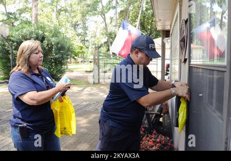 Houston, TX, USA-10 Giugno 2015 i membri del Disaster Survivor Assistance Team (DSAT) Ramon Colon, Right, e Lisa Jackson appendono un pacchetto informativo con amuleti inglesi e spagnoli su come registrarsi alla FEMA. I residenti colpiti dalle recenti inondazioni sono incoraggiati a registrarsi per il leasing di assistenza in caso di calamità chiama il numero 1-800-621-3362 (FEMA) o TTY: 1-800-462-7585 o online a www.disastperassistance.gov o m.fema.gov con un hone intelligente. Jocelyn. Houston, TX, USA-10 giugno 2015--i membri del team di assistenza per il soccorso in caso di disastro (DSAT) Ramon Colon, Right, e Lisa Jackson appendono un pacchetto informativo con l'inglese e. Foto Stock