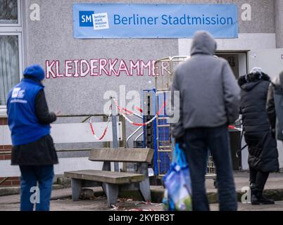 Berlino, Germania. 28th Nov 2022. Persone bisognose si trovano di fronte al negozio di abbigliamento Berliner Stadtmission durante il tempo di distribuzione. Tra le altre cose, la Missione cittadina di Berlino gestisce un armadio di abbigliamento, un rifugio di emergenza per i senzatetto e una clinica ambulatoriale per le persone bisognose non assicurate a Lehrter Straße. (A dpa ''il bisogno sta aumentando' - le donazioni per i senzatetto diminuiscono drasticamente') Credit: Monika Skolimowska/dpa/Alamy Live News Foto Stock