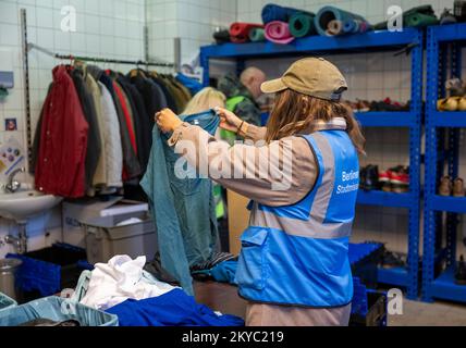 Berlino, Germania. 28th Nov 2022. Un dipendente della Berliner Stadtmission ordina gli abiti donati nel negozio di abbigliamento. Tra le altre cose, la Missione cittadina di Berlino gestisce un negozio di abbigliamento, un rifugio di emergenza per i senzatetto e una clinica ambulatoriale per i bisognosi non assicurati a Lehrter Straße. (A dpa ''il bisogno sta aumentando' - le donazioni per i senzatetto stanno diminuendo drasticamente') Credit: Monika Skolimowska/dpa/Alamy Live News Foto Stock