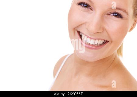 Sorriso dolce e radioso. Studio shot di una giovane donna sorridente molto alla fotocamera. Foto Stock