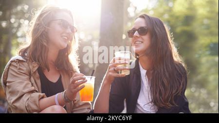Dove theres mai un amico theres un partito. due giovani amici che si gustano un drink insieme all'aperto. Foto Stock