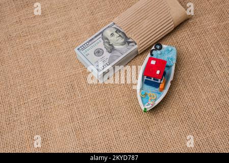 Modello barca e bundle di banconote di dollari su tela Foto Stock