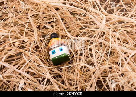 Piccolo modello giocattolo hut collocato su sfondo di paglia Foto Stock