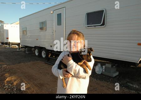 Uragano Katrina, Pascagoula, sig.ra, 2 novembre 2005 -- Brianna Edson ed il suo nuovo cane Dixie davanti al rimorchio di corsa che serve come loro sede temporanea con la madre di Brianna Wendy (non illustrata) al luogo di emergenza del gruppo di Ingalls-Wright (EGS). FEMA sta usando molti metodi per ospitare temporaneamente i residenti del Mississippi sfollati dall'uragano Katrina. Foto Stock