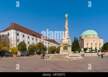 Pecs, Ungheria - 13 ottobre 2022: Vista sulla Piazza Szechenyi nel centro di Pécs con la Statua della Santissima Trinità e la Moschea di Pasha Qasim Foto Stock