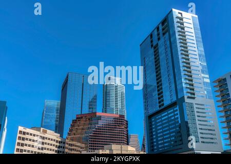 Austin, Texas - paesaggio urbano con alti edifici moderni con un riflesso del cielo blu. Vista bassa degli edifici dal design moderno rispetto al blu Foto Stock