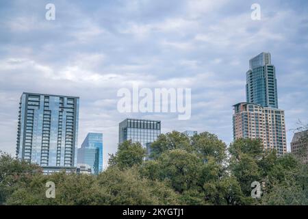 Residenziali e imprese ad alto rischio contro il cielo nuvoloso - Austin, Texas. Ci sono alberi sotto la vista della città dal Butler Metro Park. Foto Stock