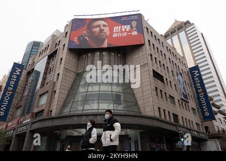 SHANGHAI, CINA - 1 DICEMBRE 2022 - i pedoni passano una grande pubblicità di messi su un edificio a Nanjing Road Pedestrian Mall a Shanghai, Cina, Foto Stock