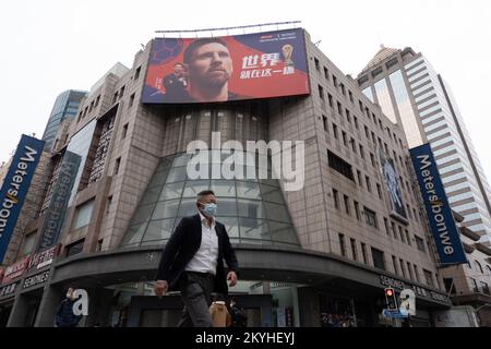 SHANGHAI, CINA - 1 DICEMBRE 2022 - i pedoni passano una grande pubblicità di messi su un edificio a Nanjing Road Pedestrian Mall a Shanghai, Cina, Foto Stock