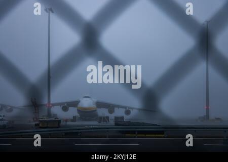 Schkeuditz, Germania. 01st Dec, 2022. Un Antonov An-124 ucraino si trova nella nebbia all'aeroporto di Lipsia/Halle. L'aeromobile appartiene alla Antonov Airlines dell'Ucraina e opera per gli stati membri della NATO in base all'accordo di Salis. Tre giganteschi combattenti dello stesso tipo del gruppo russo Volga-Dnepr sono bloccati e non sono più autorizzati a decollare perché lo spazio aereo dell'UE è chiuso agli aerei russi. Credit: Jan Woitas/dpa/Alamy Live News Foto Stock