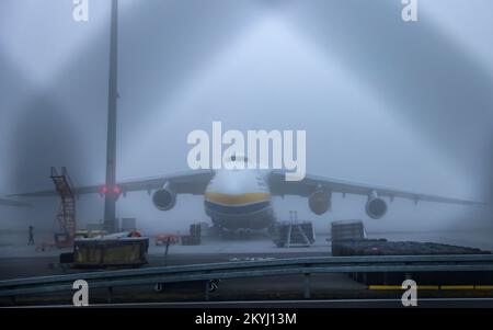 Schkeuditz, Germania. 01st Dec, 2022. Un Antonov An-124 ucraino si trova nella nebbia all'aeroporto di Lipsia/Halle. L'aeromobile appartiene alla Antonov Airlines dell'Ucraina e opera per gli stati membri della NATO in base all'accordo di Salis. Tre giganteschi combattenti dello stesso tipo del gruppo russo Volga-Dnepr sono bloccati e non sono più autorizzati a decollare perché lo spazio aereo dell'UE è chiuso agli aerei russi. Credit: Jan Woitas/dpa/Alamy Live News Foto Stock
