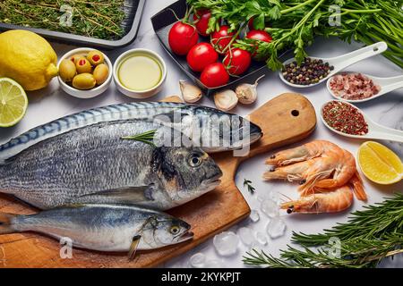 Pesce fresco cibo sfondo. Diversi frutti di mare, gamberetti e caviale rosso. Pesce per cucinare con erbe, verdure e spezie isolate su sfondo bianco Foto Stock