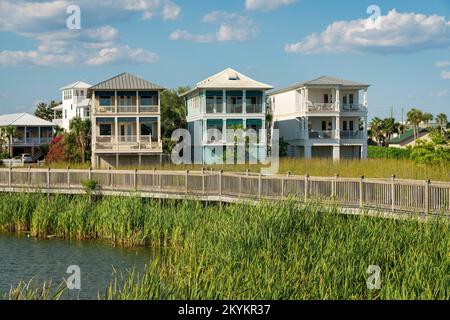 Destin, Florida- passeggiata sul lungomare con ringhiere in legno sopra il lago di una zona residenziale. Percorso sopra le piante di erba alta in un lago vicino a. Foto Stock