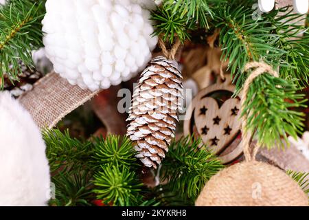 Ornamento naturale dell'albero di Natale bauble fatto di cono di pino con vernice bianca Foto Stock