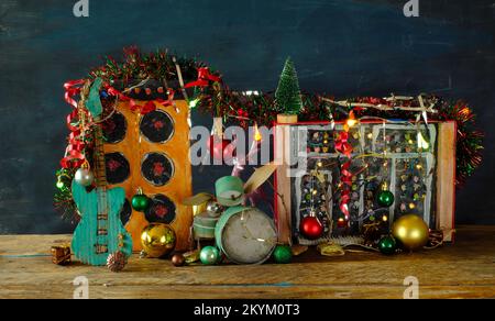 Strumenti musicali per natale con modelli di cartone grungo di strumenti musicali, sintetizzatore, drum kit, chitarra, amplificatore, microfono e natale Foto Stock