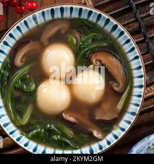 Mangiare il grande tangyuan yuanxiao (tang yuan, palle glutinose di riso gnocchi) con una zuppa saporita in una ciotola per il festival del solstizio d'inverno. Foto Stock