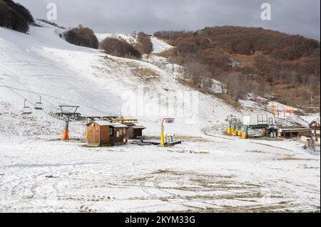 Limone Piemonte (Cuneo), Italia. 1st dicembre 2022. La mancanza di precipitazioni nelle Alpi Marittime fa temere un altro anno di neve nelle stazioni sciistiche, probabilmente a causa del cambiamento climatico che si sta svolgendo a livello globale. L'immagine mostra gli impianti di risalita a quota 1400 in un paesaggio praticamente privo di neve: Come lo scorso anno, i gestori dovranno ricorrere alla neve artificiale. Credit: Luca Presentia / Alamy Live News Foto Stock