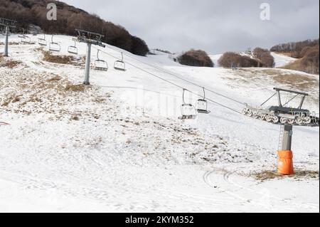 Limone Piemonte (Cuneo), Italia. 1st dicembre 2022. La mancanza di precipitazioni nelle Alpi Marittime fa temere un altro anno di neve nelle stazioni sciistiche, probabilmente a causa del cambiamento climatico che si sta svolgendo a livello globale. L'immagine mostra gli impianti di risalita a quota 1400 in un paesaggio praticamente privo di neve: Come lo scorso anno, i gestori dovranno ricorrere alla neve artificiale. Credit: Luca Presentia / Alamy Live News Foto Stock