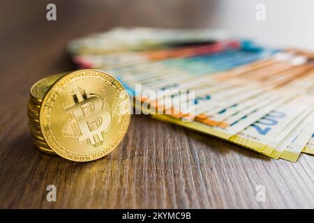 Criptovaluta. Denaro virtuale Bitcoin. Monete d'oro e banconote in euro. Foto Stock