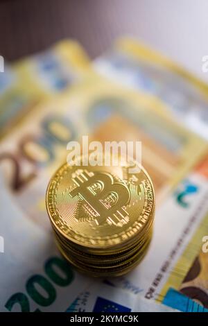 Criptovaluta. Denaro virtuale Bitcoin. Monete d'oro e banconote in euro. Foto Stock