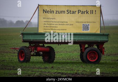 01 dicembre 2022, Sassonia-Anhalt, Gröbers: Un manifesto di protesta contro la zona industriale di Star Park II con l'iscrizione "No a Star Park II" è parcheggiato su un rimorchio in un campo. La zona industriale "Star Park II" di circa 200 ettari vicino a Halle non deve essere costruita. Il consiglio locale di Kabelsketal (Saalekreis) ha deciso contro il progetto. A Kabelsketal si è manifestata resistenza contro l'espansione della zona industriale "Star Park i" da parte del nuovo "Star Park II". Un'iniziativa dei cittadini teme ulteriori oneri per le persone, la natura e l'ambiente attraverso il traffico aggiuntivo e. Foto Stock