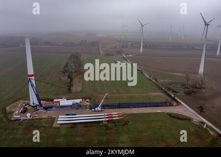 01 dicembre 2022, Sassonia-Anhalt, Dessau-Roßlau: Gli ultimi segmenti di torre, mozzo e pale di rotore sono pronti per l'assemblaggio di una turbina eolica presso la centrale eolica di Quellendorf. Nei prossimi giorni, più pale del rotore saranno trasportate da Köthen alla centrale eolica con un veicolo speciale. Ciò comporterà la chiusura temporanea delle strade per il trasporto pesante. Foto: Jan Woitas/dpa/ZB Foto Stock