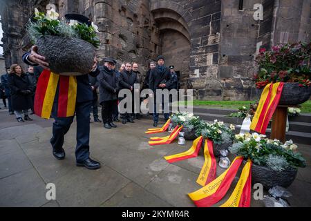 Treviri, Germania. 01st Dec, 2022. Un vigile del fuoco porta una ciotola di fiori con un arco di fronte alla porta-Nigra per commemorare le vittime e feriti del bastone nel centro di Treviri il 1 dicembre 2020. Due anni dopo il bastione di Treviri, la città ha commemorato le vittime. Credit: Harald Tittel/dpa/Alamy Live News Foto Stock