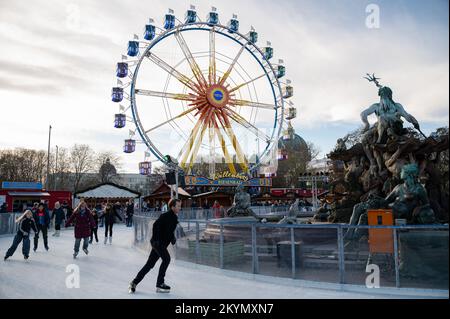 27.11.2022, Berlino, Germania, Europa - i visitatori pattinano sul ghiaccio sulla pista di pattinaggio intorno alla Fontana di Nettuno al mercatino di Natale ad Alexanderplatz. Foto Stock