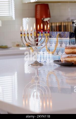 Simbolo di festa ebrea Hanukkah luminoso che risplende su sfondo sfocato Hanukkiah Menorah Foto Stock