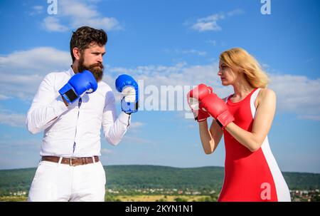 Relazioni come concetto di lotta. Uomo e donna lotta boxe guanti blu cielo sfondo. Coppia in lotta amore. Relazioni e vita familiare come ogni giorno Foto Stock