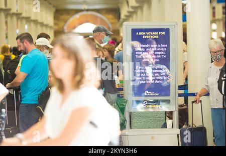 I viaggiatori passano davanti a un messaggio per i passeggeri visualizzato su una scheda elettrica presso la stazione di St Pancras nel centro di Londra. Foto Stock