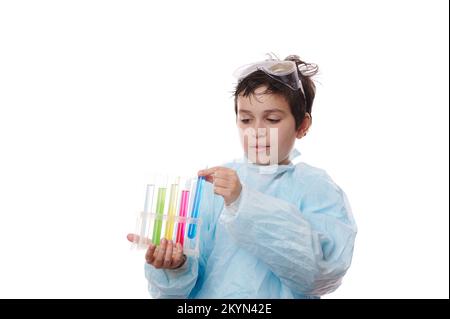 Primo piano ragazzo adolescente intelligente, giovane pupillo chimico in camice da laboratorio, conduce esperimenti chimici isolati su sfondo bianco Foto Stock