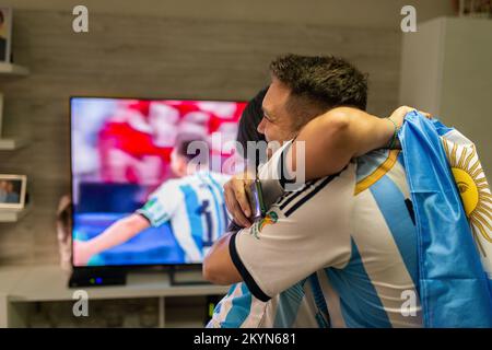 I fan argentini abbracciano l'altro celebrando l'obiettivo di messi contro il Messico durante la Coppa del mondo FIFA Qatar 2022. Foto Stock