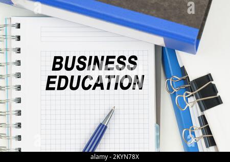 Business ed Economia. Tra i documenti, cartelle, un notebook con l'iscrizione - BUSINESS EDUCATION Foto Stock