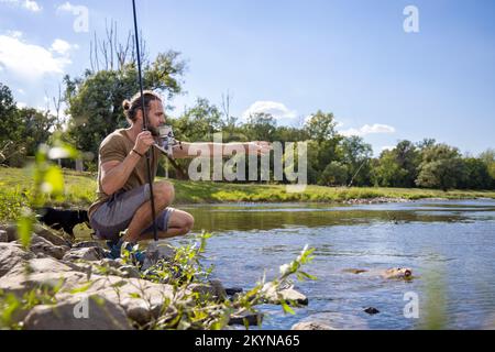 Hobby fisher catturato un pesce in un fiume Foto Stock