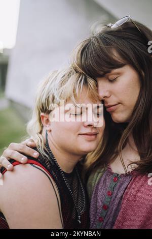 Giovane coppia con gli occhi chiusi abbracciandosi l'un l'altro Foto Stock