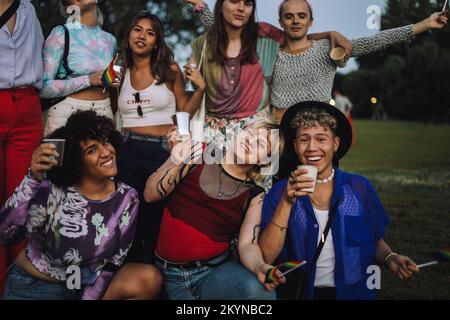 Ritratto di amici felici che si divertono insieme al parco durante il tramonto Foto Stock