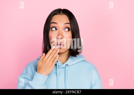 Foto ritratto di bella giovane donna coprire bocca oops errore guardare spazio vuoto vestito elegante vestito blu isolato su sfondo di colore rosa Foto Stock