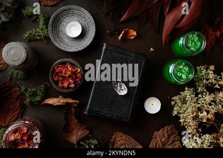 Concetto di vita still witchcraft con pozione, libro incantesimo, erbe ingredienti candele e attrezzature magiche Foto Stock
