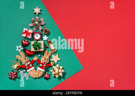 Silhouette di albero di Natale fatta di giocattoli su sfondo verde. Buon Natale e felice anno nuovo concetto Foto Stock