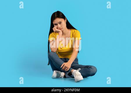 Triste sconvolto stanco studente donna coreana millenario seduto sul pavimento, sofferente di pressione e lavoro eccessivo Foto Stock