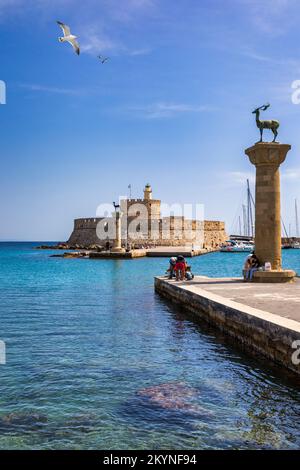 Porto di MANDRAKI con statua di cervi, dove si trovava il Colosso e forte di San Nicola. Rodi, Grecia. Statua di Hirschkuh al posto del Coloss Foto Stock