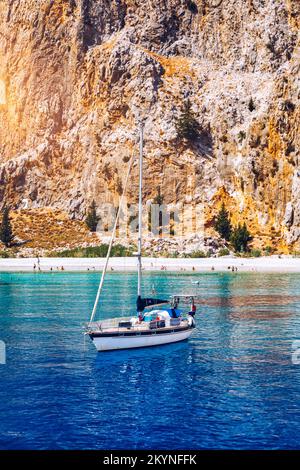 Baia di San Giorgio sull'isola di Symi, sosta popolare per i turisti per fare una nuotata nelle acque turchesi, isola di Symi, Grecia. Barca a vela al Symi Foto Stock