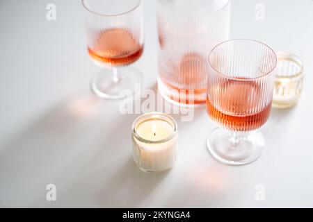Vino rosato in vitelle alla moda e decanter su tavola bianca Foto Stock