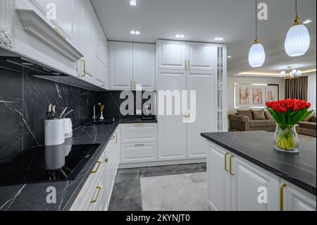 Grande bianco e nero costoso ben progettato cucina moderna negli interni studio, banco in marmo nero Foto Stock