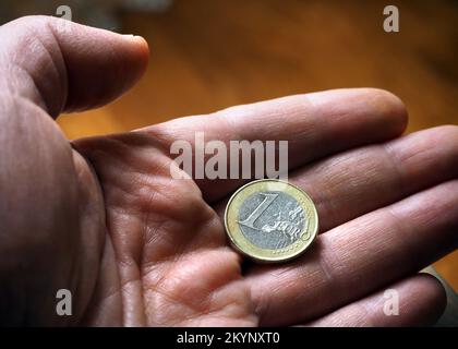 Un euro di moneta. Moneta da 1 euro nel palmo della mano. Foto Stock